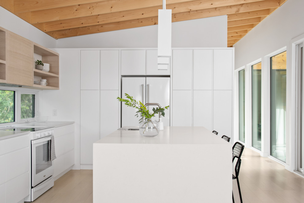 Photo of a scandi kitchen in Other with flat-panel cabinets, white cabinets, engineered stone countertops, white appliances and an island.