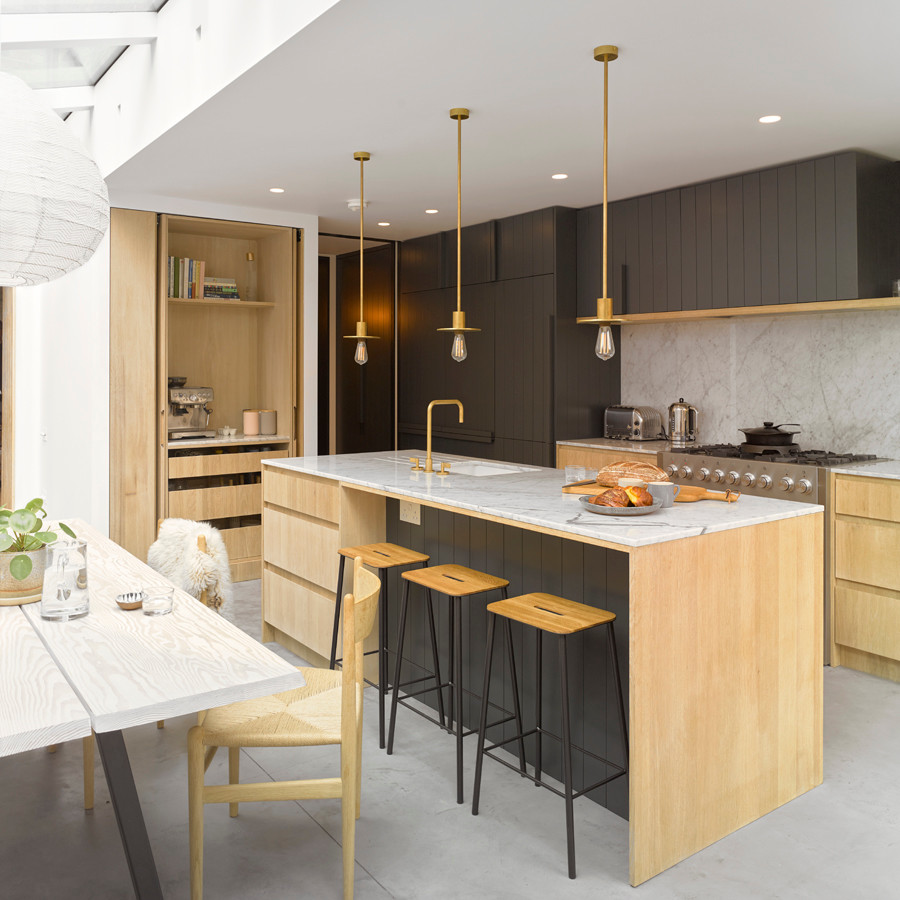 Foto på ett mellanstort funkis linjärt kök och matrum, med en undermonterad diskho, släta luckor, marmorbänkskiva, vitt stänkskydd, rostfria vitvaror, betonggolv, en köksö och grått golv