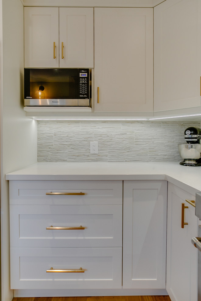 Exempel på ett mellanstort vit vitt kök, med en undermonterad diskho, skåp i shakerstil, vita skåp, bänkskiva i kvarts, flerfärgad stänkskydd, stänkskydd i porslinskakel, rostfria vitvaror och mellanmörkt trägolv