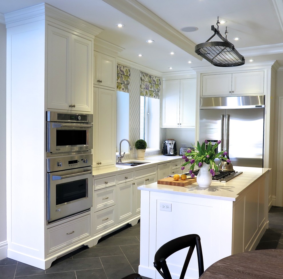 Large victorian kitchen/diner in Montreal with a submerged sink, beaded cabinets, white cabinets, engineered stone countertops, white splashback, glass tiled splashback, stainless steel appliances, ceramic flooring and an island.