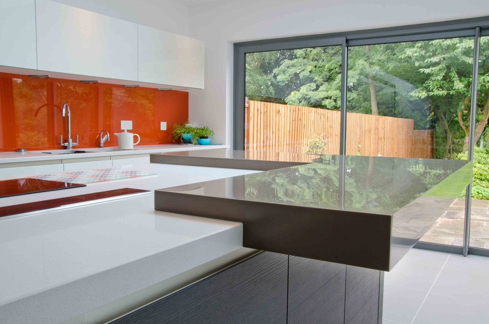 Источник вдохновения для домашнего уюта: отдельная кухня в современном стиле с монолитной мойкой, плоскими фасадами, оранжевым фартуком, фартуком из стекла, полом из керамической плитки и островом