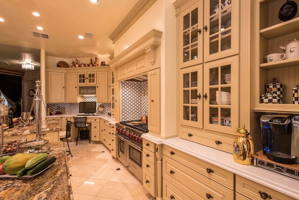 Design ideas for a large victorian u-shaped enclosed kitchen in San Diego with raised-panel cabinets, beige cabinets, engineered stone countertops, white splashback, ceramic splashback, travertine flooring, multiple islands and beige floors.