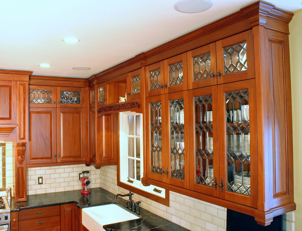 Foto på ett stort amerikanskt kök, med en rustik diskho, luckor med upphöjd panel, skåp i mellenmörkt trä, bänkskiva i täljsten, gult stänkskydd, stänkskydd i keramik, integrerade vitvaror, klinkergolv i keramik, en köksö och flerfärgat golv