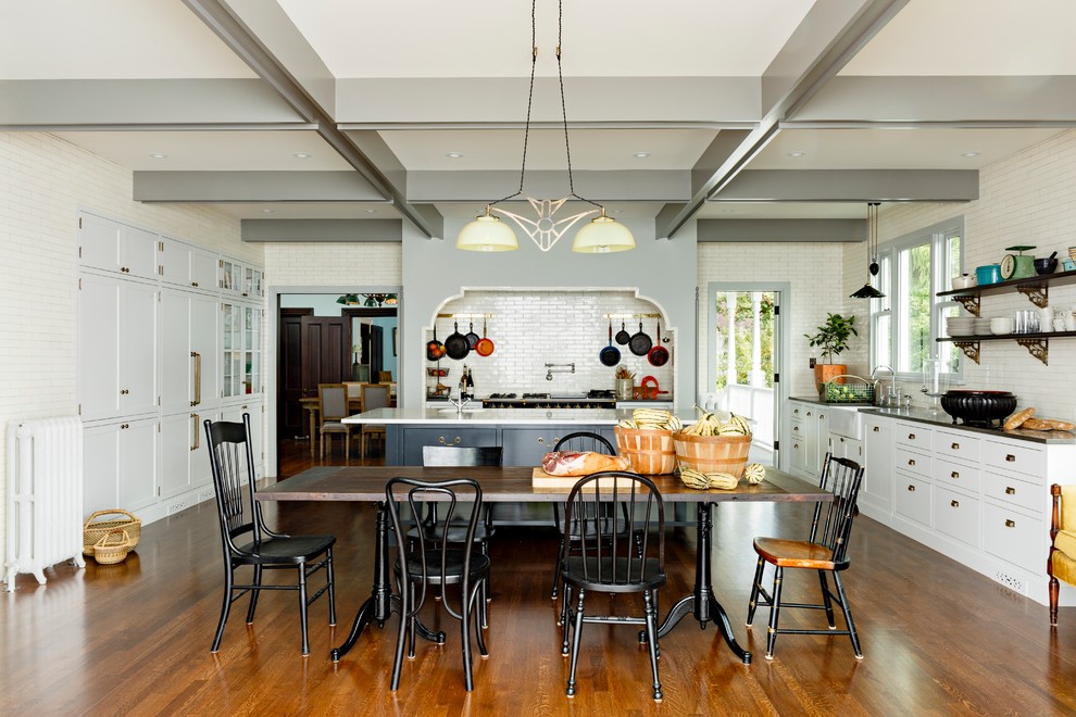 Example of an ornate eat-in kitchen design in Portland with a farmhouse sink, shaker cabinets, gray cabinets, marble countertops, black appliances, white backsplash and subway tile backsplash