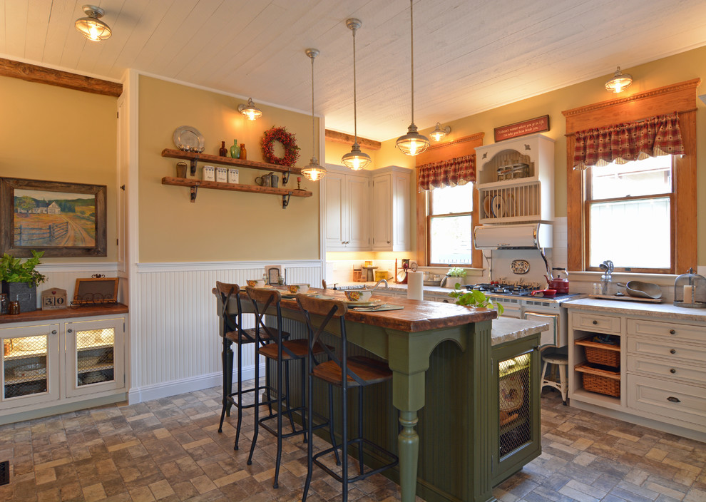 Inspiration for a small victorian l-shaped enclosed kitchen in San Luis Obispo with raised-panel cabinets, white cabinets, quartz worktops, white splashback, metro tiled splashback, an island, white worktops, a belfast sink, integrated appliances, brick flooring and grey floors.