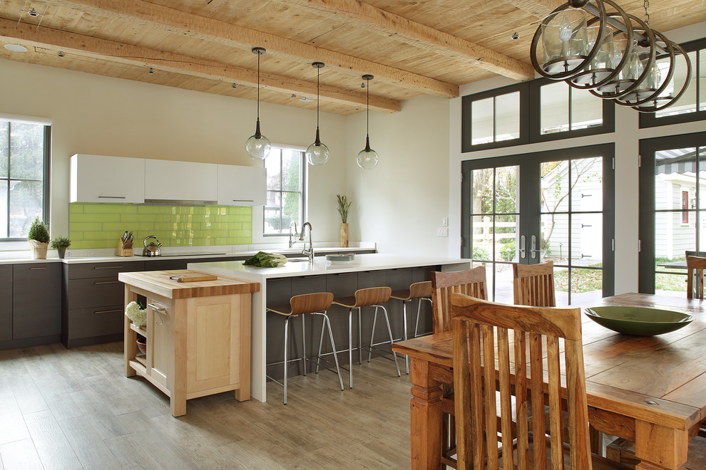 Bild på ett mellanstort vintage kök, med en enkel diskho, släta luckor, grå skåp, marmorbänkskiva, grönt stänkskydd, stänkskydd i porslinskakel, rostfria vitvaror, ljust trägolv och en köksö