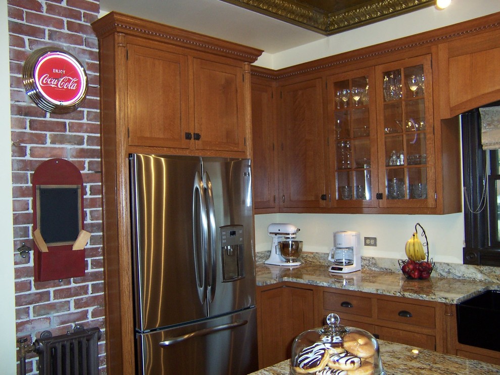 Landhaus Küche in U-Form mit Landhausspüle, Schrankfronten mit vertiefter Füllung, hellbraunen Holzschränken, Granit-Arbeitsplatte und Küchengeräten aus Edelstahl in Chicago