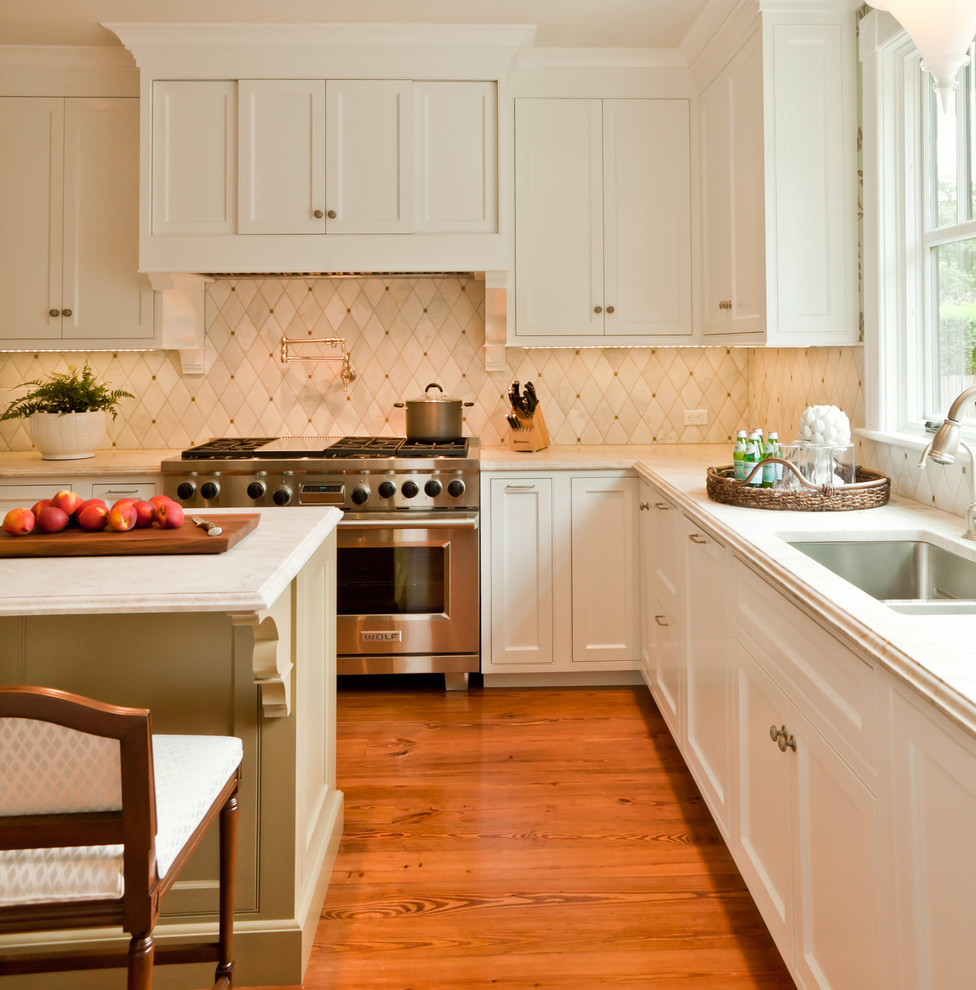 Cette image montre une cuisine traditionnelle avec un évier encastré, un plan de travail en granite et un électroménager en acier inoxydable.