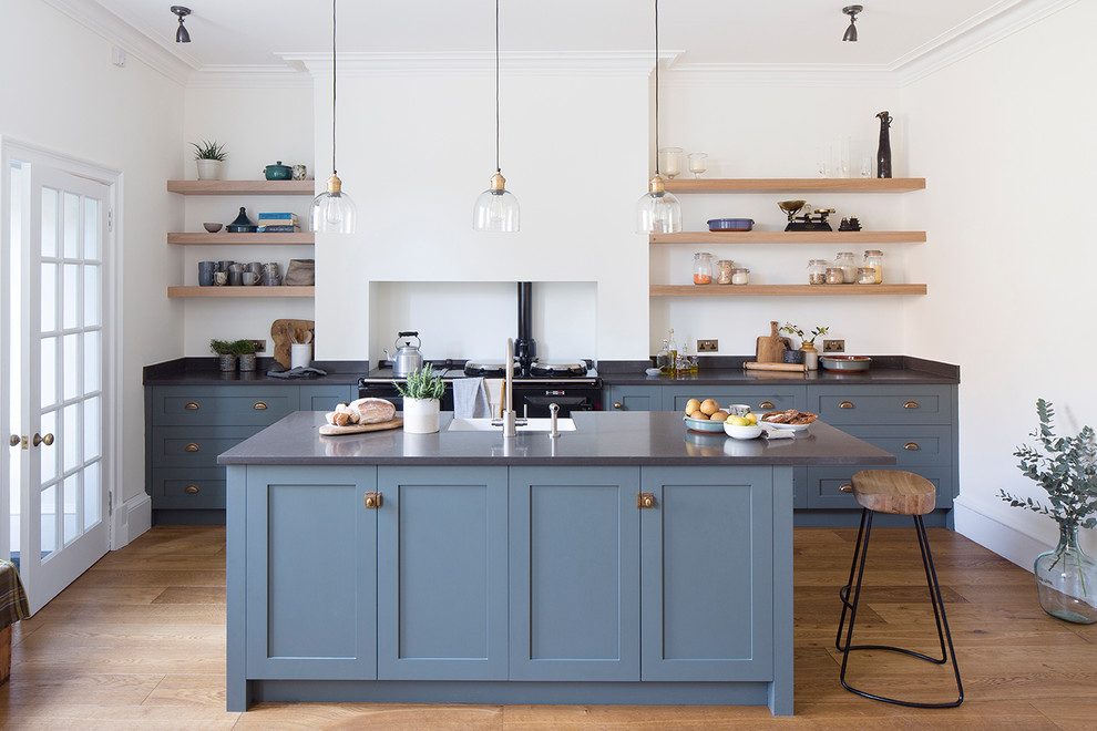 Einzeilige, Mittelgroße Eklektische Wohnküche mit Landhausspüle, Schrankfronten im Shaker-Stil, blauen Schränken, Quarzwerkstein-Arbeitsplatte, schwarzen Elektrogeräten und Kücheninsel in Edinburgh