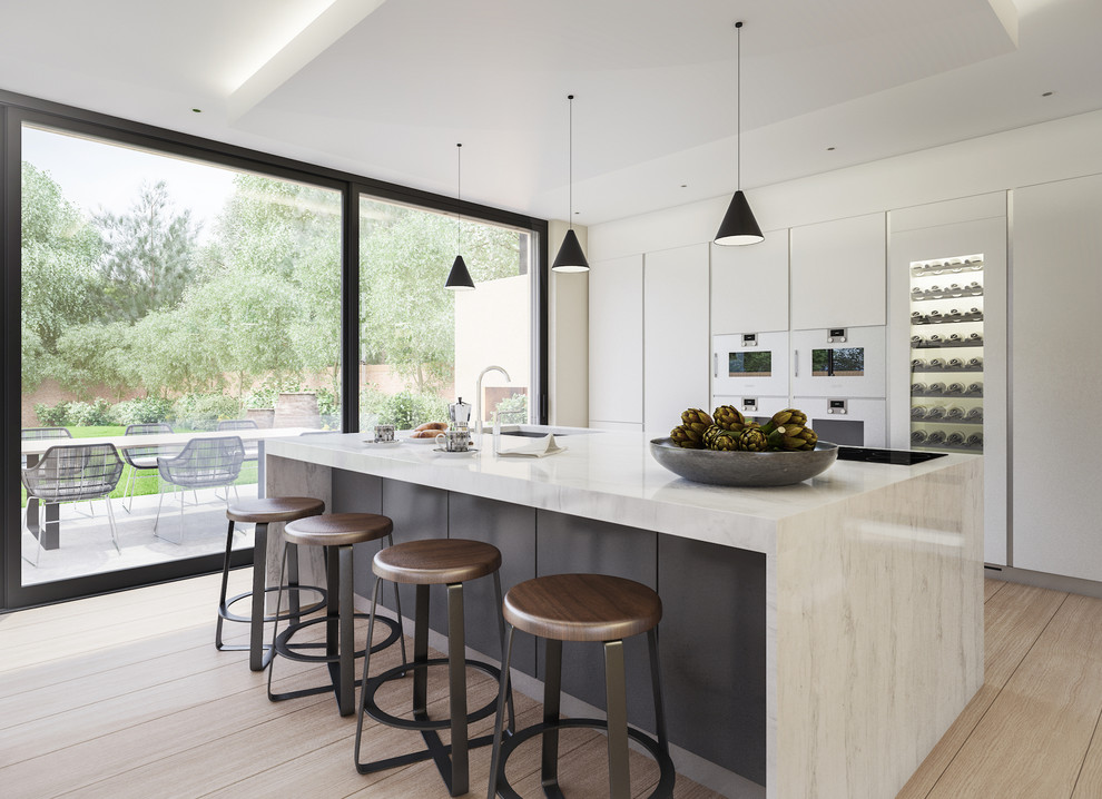 Open concept kitchen - huge contemporary light wood floor open concept kitchen idea in London with a drop-in sink, flat-panel cabinets, white cabinets, solid surface countertops, stainless steel appliances and an island