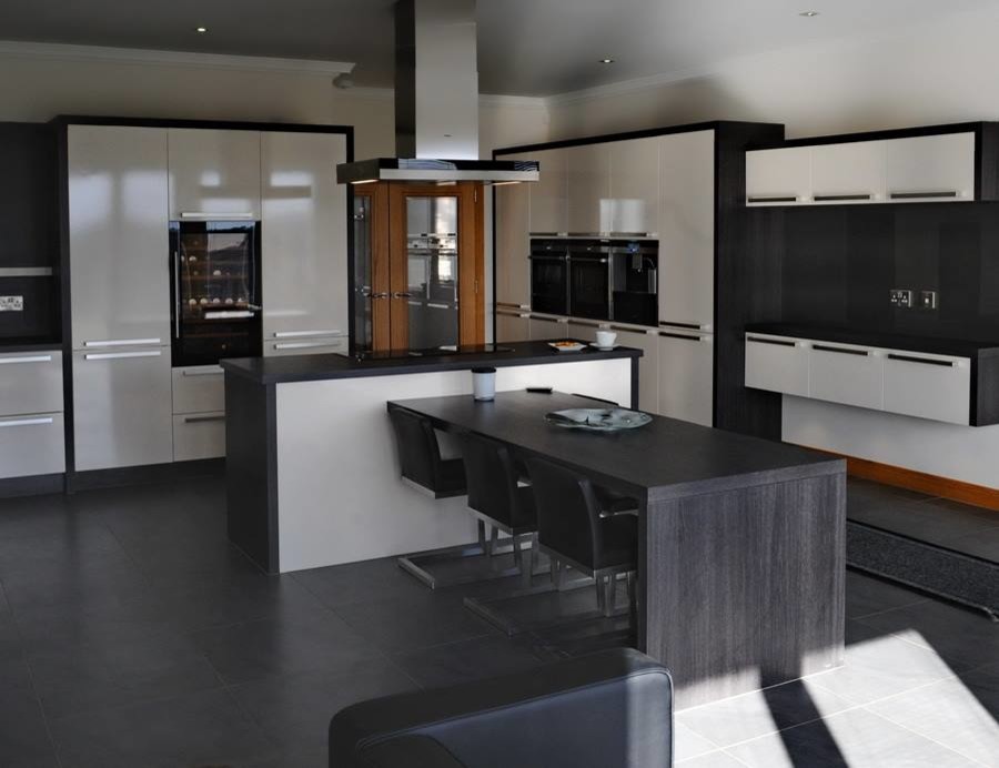 Photo of a large contemporary u-shaped open plan kitchen in Other with an integrated sink, flat-panel cabinets, beige cabinets, laminate countertops, black splashback, integrated appliances, ceramic flooring and an island.