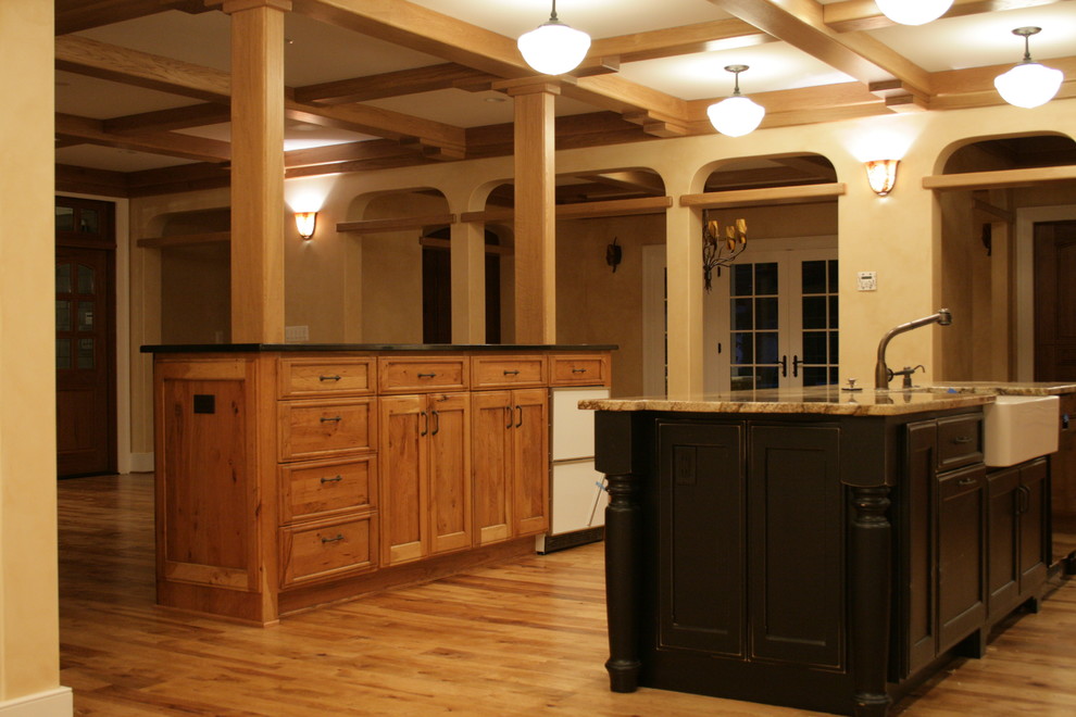 На фото: параллельная кухня-гостиная в классическом стиле с с полувстраиваемой мойкой (с передним бортиком), темными деревянными фасадами, гранитной столешницей и техникой из нержавеющей стали с
