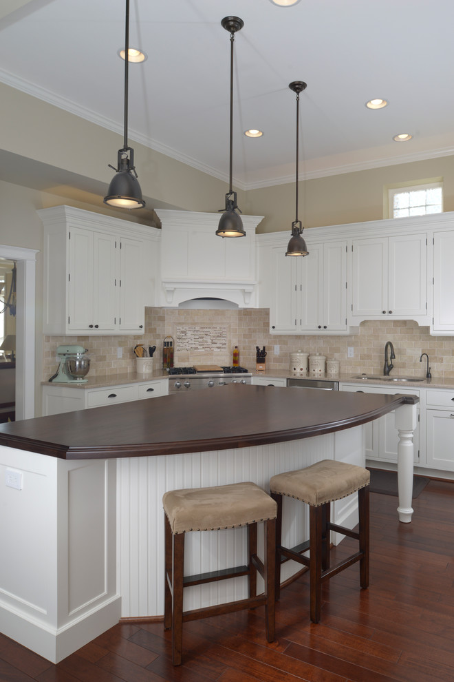 Traditional l-shaped open plan kitchen in Chicago with a submerged sink, beaded cabinets, white cabinets, wood worktops, beige splashback, stone tiled splashback, stainless steel appliances, dark hardwood flooring and an island.