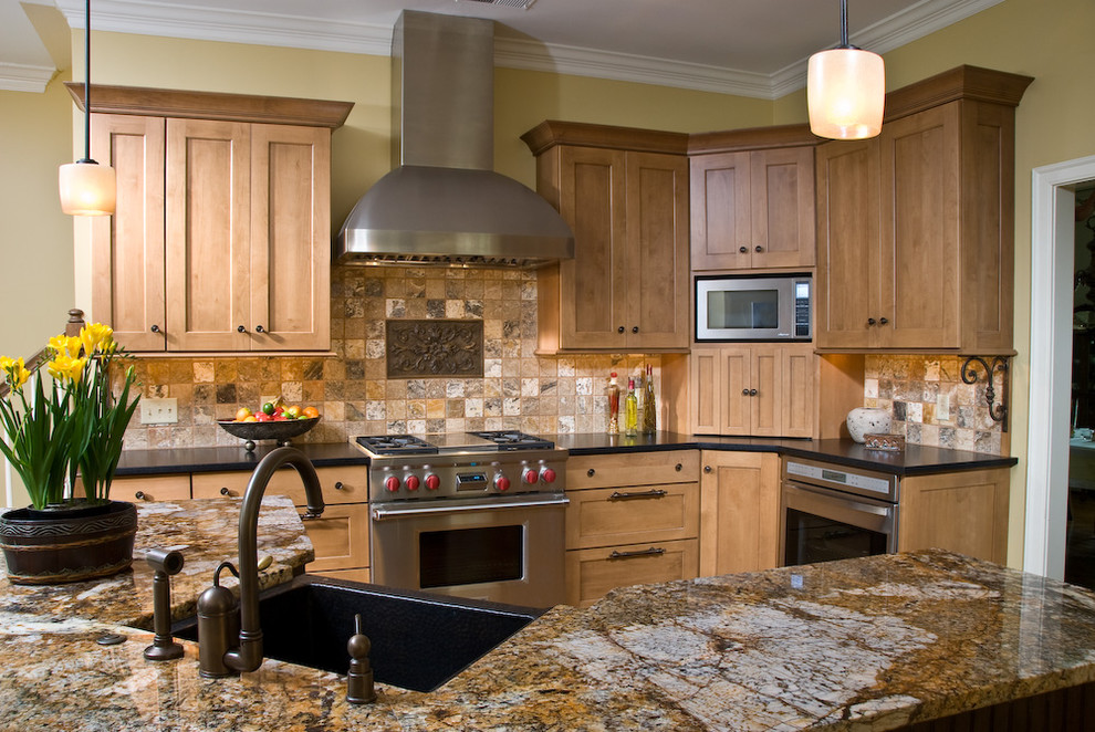 На фото: кухня в классическом стиле с гранитной столешницей, барной стойкой, мойкой в углу и красивой плиткой с