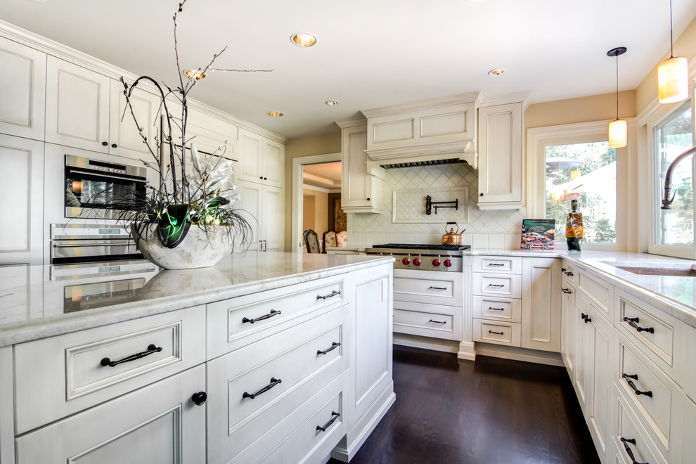 Inspiration for a large timeless u-shaped dark wood floor open concept kitchen remodel in Seattle with an undermount sink, recessed-panel cabinets, white cabinets, granite countertops, ceramic backsplash, stainless steel appliances and an island