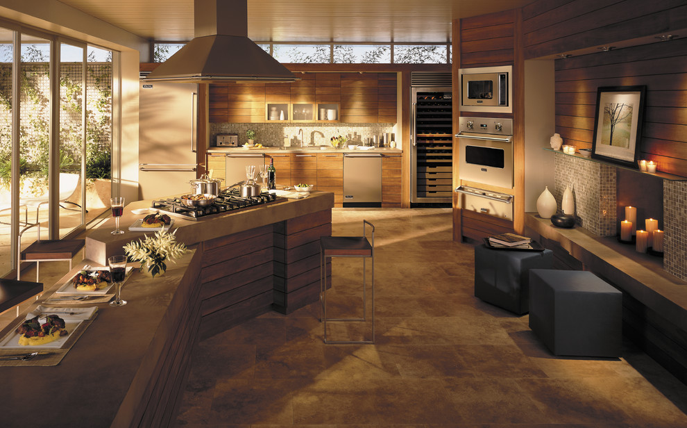 Ejemplo de cocina actual con encimera de cemento, salpicadero marrón, salpicadero con mosaicos de azulejos, electrodomésticos de colores y suelo de travertino
