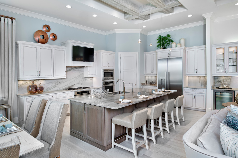 Open concept kitchen - transitional open concept kitchen idea in Miami with an undermount sink, white cabinets, white backsplash, marble backsplash, stainless steel appliances and an island