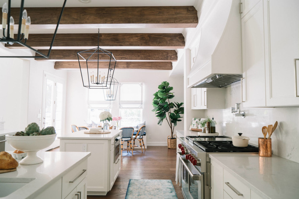 Foto de cocina comedor tradicional renovada grande con fregadero encastrado, armarios estilo shaker, puertas de armario blancas, electrodomésticos de acero inoxidable, suelo de madera oscura, dos o más islas y suelo marrón