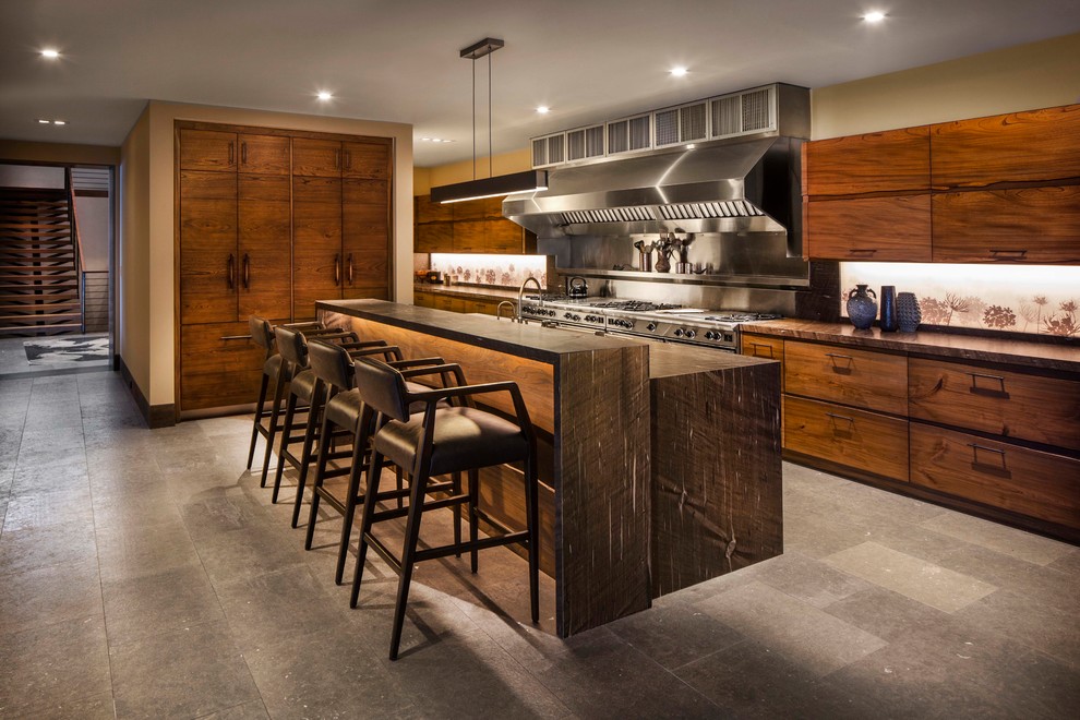 Свежая идея для дизайна: большая угловая кухня-гостиная в современном стиле с плоскими фасадами, темными деревянными фасадами, островом, серым полом, коричневой столешницей и техникой из нержавеющей стали - отличное фото интерьера