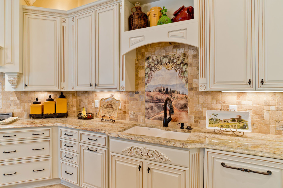 Photo of a large mediterranean u-shaped kitchen/diner in Miami with a submerged sink, raised-panel cabinets, white cabinets, granite worktops, beige splashback, porcelain splashback, stainless steel appliances, porcelain flooring and an island.