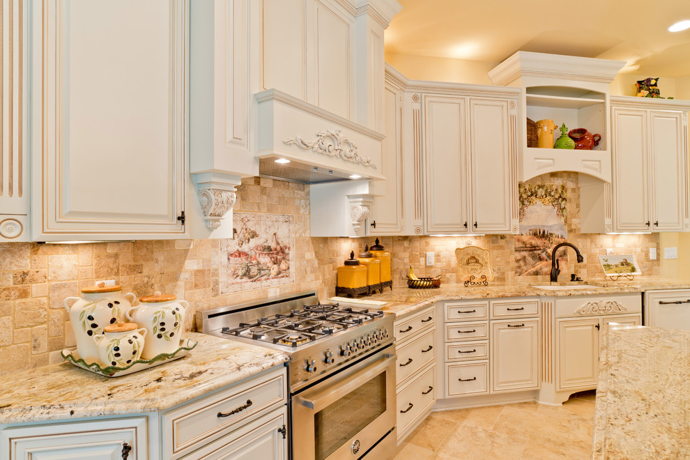 Large tuscan u-shaped porcelain tile eat-in kitchen photo in Miami with an undermount sink, raised-panel cabinets, white cabinets, granite countertops, beige backsplash, porcelain backsplash, stainless steel appliances and an island