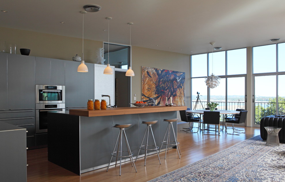 Offene Moderne Küchenbar mit Arbeitsplatte aus Holz, flächenbündigen Schrankfronten, grauen Schränken und Küchengeräten aus Edelstahl in Austin