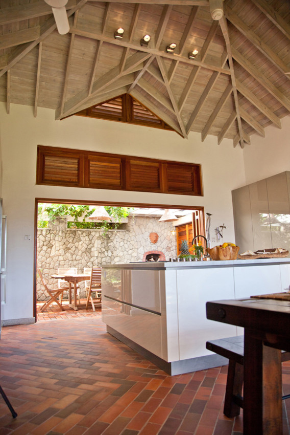 Beach style terra-cotta tile eat-in kitchen photo in Milan with white cabinets and an island