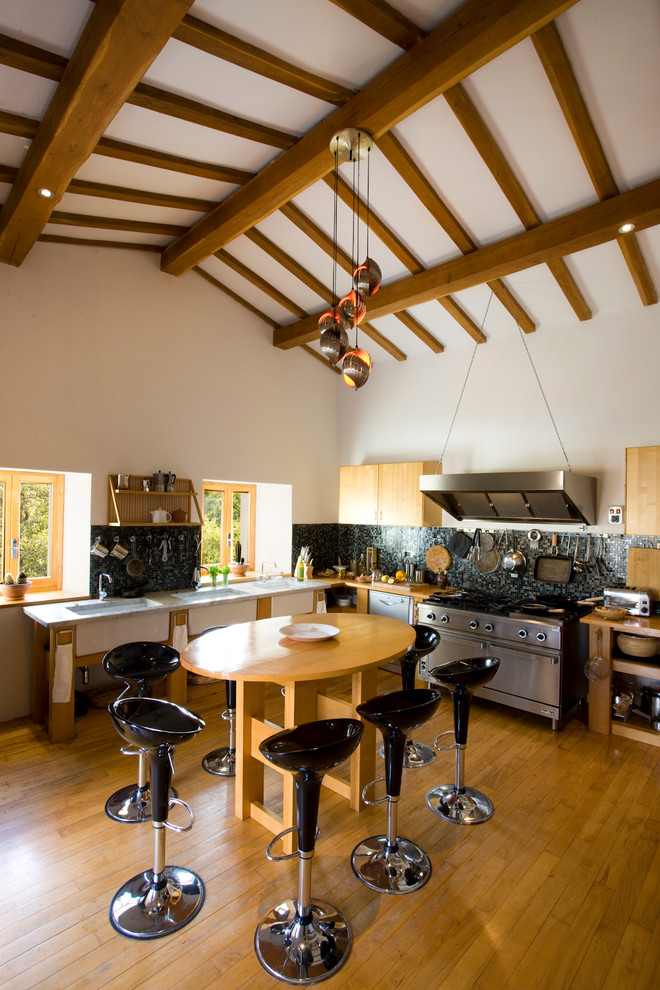 Inredning av ett eklektiskt stort kök, med öppna hyllor, skåp i ljust trä, rostfria vitvaror, ljust trägolv, en dubbel diskho, svart stänkskydd och stänkskydd i mosaik