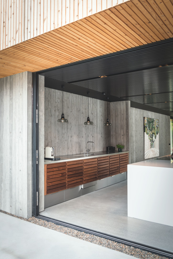Foto di una grande cucina minimal con lavello sottopiano, ante a persiana, ante in legno scuro, paraspruzzi grigio, pavimento grigio e top grigio
