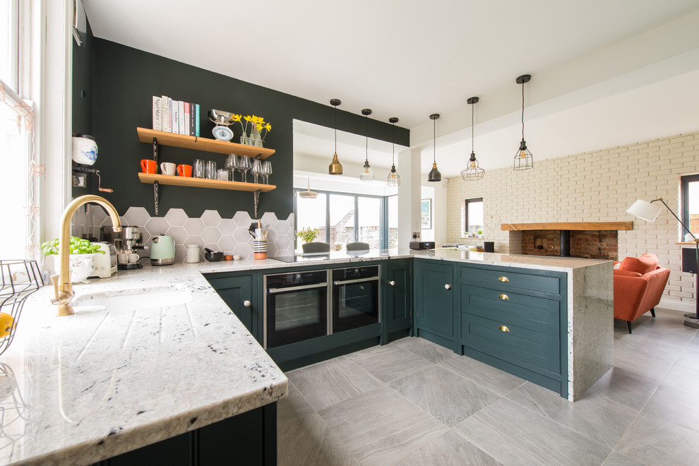 Inspiration for a traditional u-shaped kitchen in Kent with a submerged sink, shaker cabinets, green cabinets, grey splashback, mosaic tiled splashback, black appliances, no island and grey floors.
