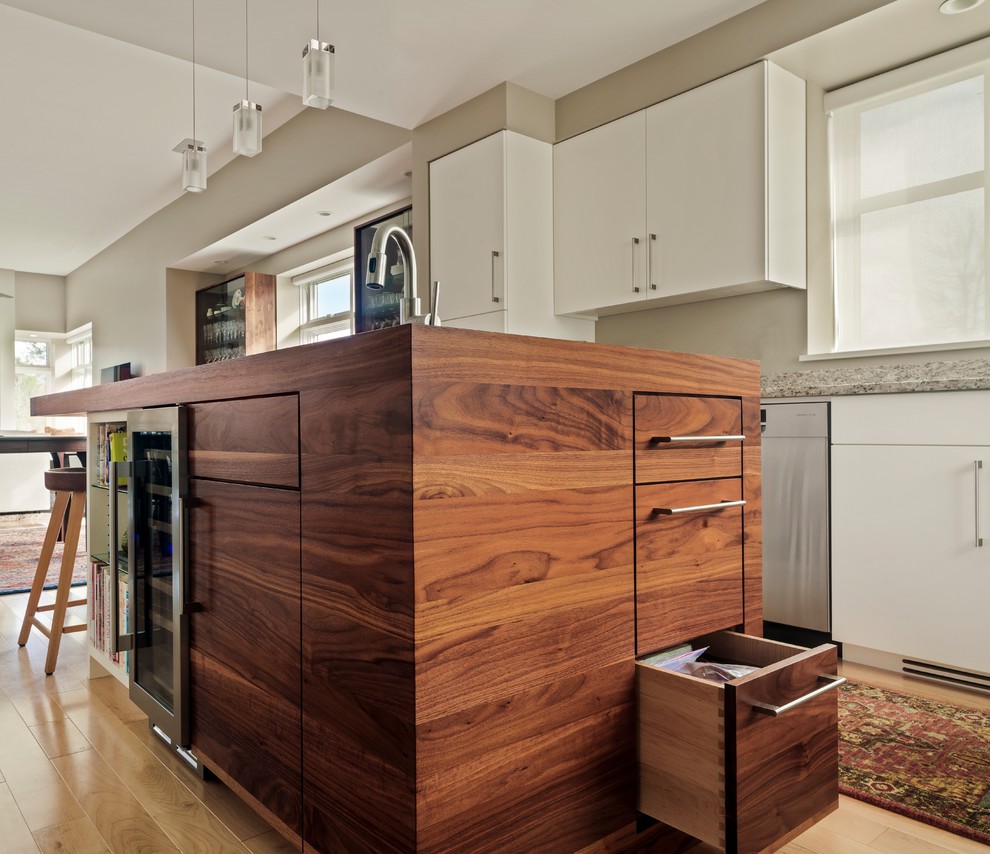 Inspiration for a mid-sized mid-century modern u-shaped light wood floor eat-in kitchen remodel in Burlington with an undermount sink, flat-panel cabinets, white cabinets, granite countertops, multicolored backsplash, stainless steel appliances and an island
