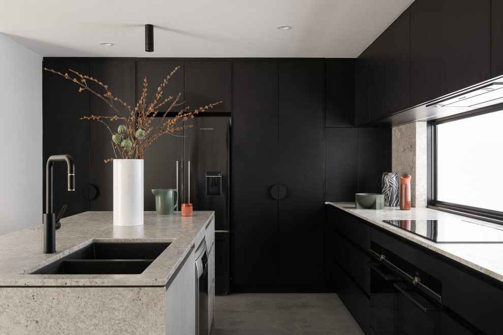 Large minimalist l-shaped concrete floor and gray floor kitchen photo in Perth with an undermount sink, black cabinets, granite countertops, window backsplash, black appliances, an island, gray countertops and flat-panel cabinets