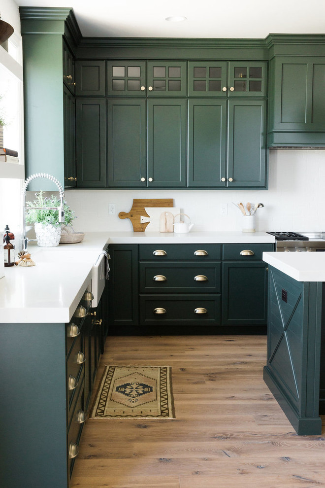 ソルトレイクシティにある中くらいなトランジショナルスタイルのおしゃれなキッチン (エプロンフロントシンク、緑のキャビネット、白いキッチンパネル、シルバーの調理設備、無垢フローリング) の写真