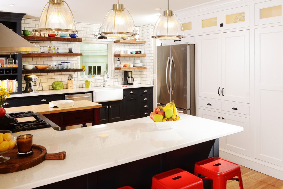 Eat-in kitchen - mid-sized eclectic u-shaped light wood floor eat-in kitchen idea in Other with recessed-panel cabinets, white cabinets, solid surface countertops, an island, a farmhouse sink, white backsplash, subway tile backsplash and stainless steel appliances