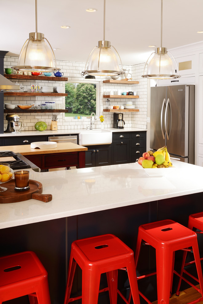 Example of a mid-sized cottage u-shaped light wood floor eat-in kitchen design in Other with a farmhouse sink, recessed-panel cabinets, white backsplash, subway tile backsplash, stainless steel appliances, an island and solid surface countertops