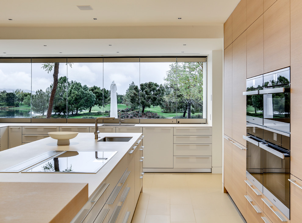 Example of a large trendy porcelain tile and beige floor open concept kitchen design in Los Angeles with an undermount sink, flat-panel cabinets, light wood cabinets, wood countertops, window backsplash, stainless steel appliances and an island
