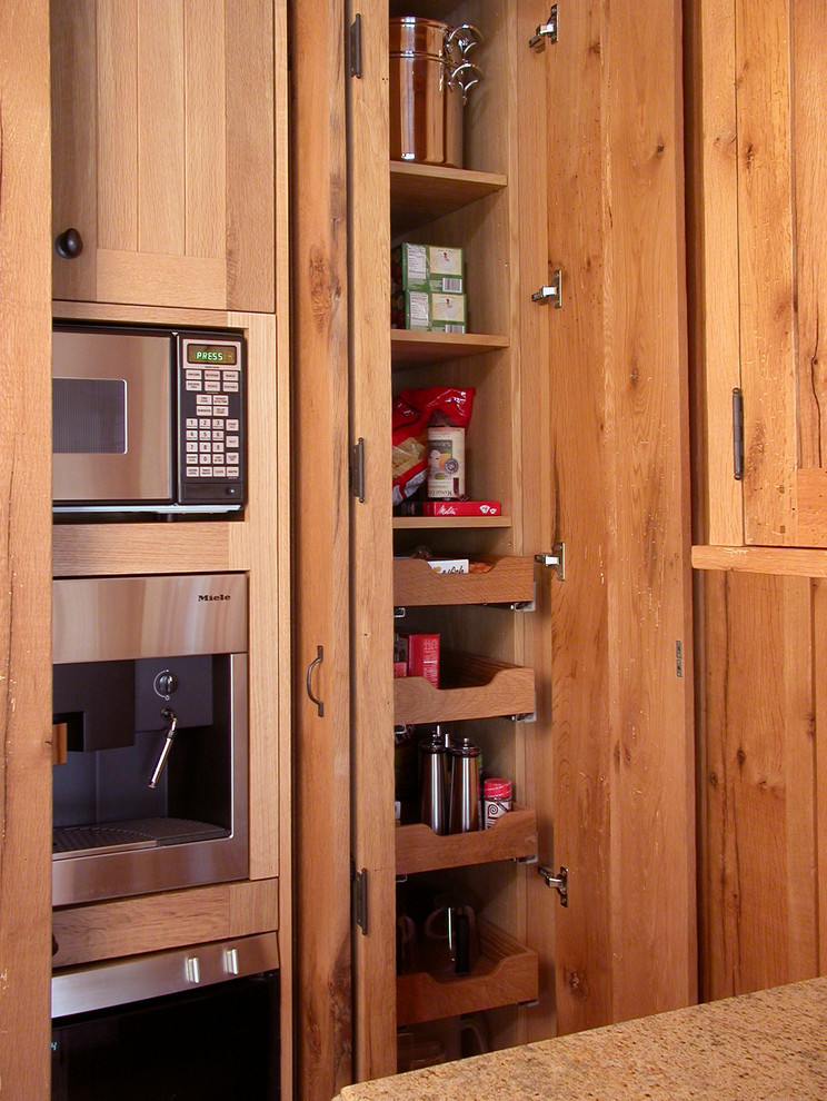 Foto di una piccola cucina con ante lisce, ante in legno scuro, elettrodomestici in acciaio inossidabile e nessuna isola