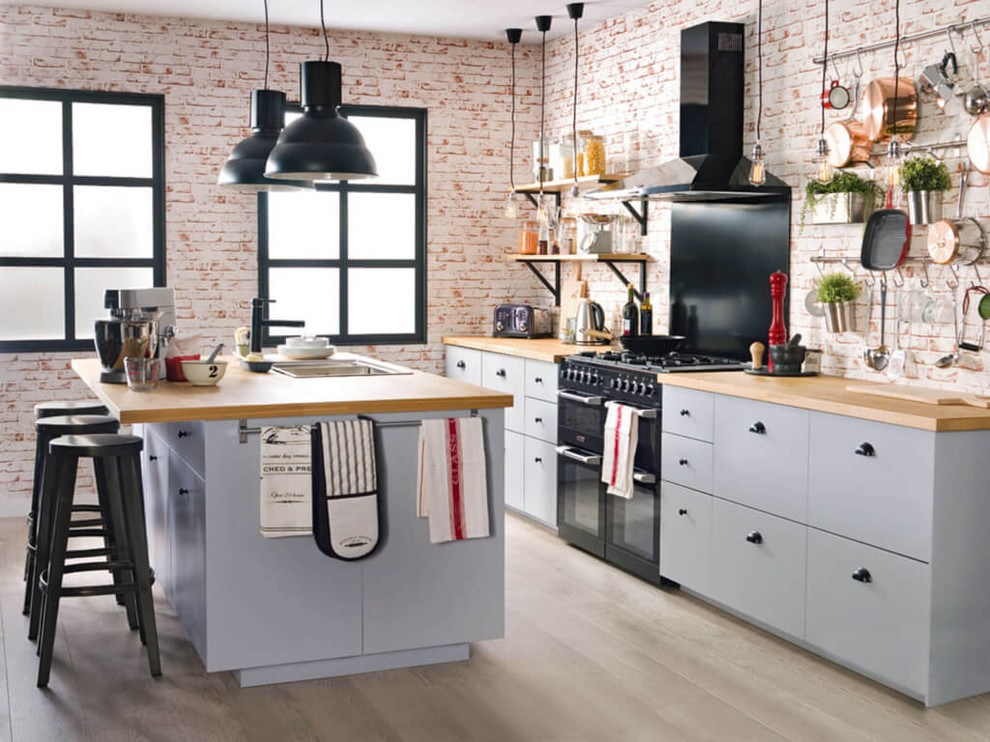 This is an example of a medium sized industrial single-wall open plan kitchen in Other with flat-panel cabinets, grey cabinets, wood worktops and an island.