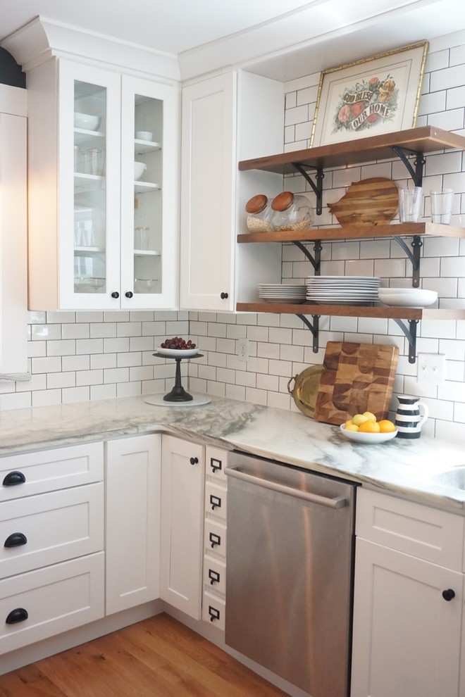 Ejemplo de cocina ecléctica con armarios estilo shaker, puertas de armario blancas, encimera de mármol, salpicadero blanco, salpicadero de azulejos tipo metro y suelo de madera clara