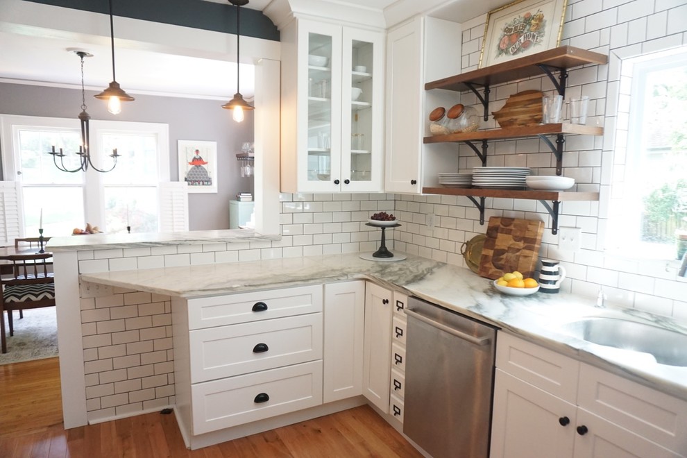 Modelo de cocina ecléctica con armarios estilo shaker, puertas de armario blancas, encimera de mármol, salpicadero blanco, salpicadero de azulejos tipo metro y suelo de madera clara