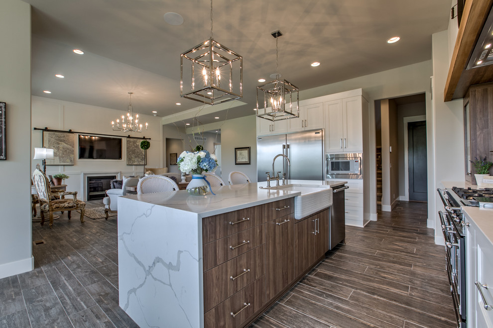 Eat-in kitchen - large eclectic l-shaped porcelain tile and gray floor eat-in kitchen idea in Omaha with a farmhouse sink, quartzite countertops, stainless steel appliances, an island, white cabinets, white backsplash, recessed-panel cabinets and ceramic backsplash