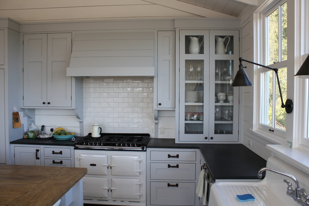 Large elegant l-shaped kitchen photo in San Francisco with subway tile backsplash, a farmhouse sink, wood countertops, gray cabinets, white backsplash, white appliances, an island and shaker cabinets