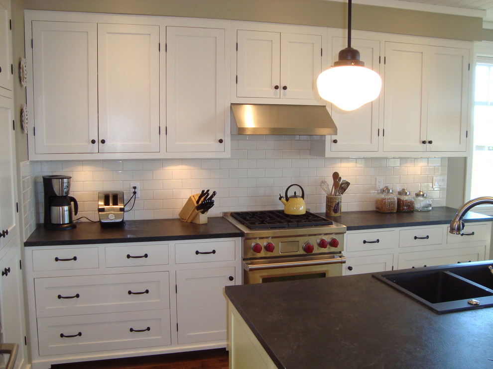 Inspiration for a farmhouse medium tone wood floor kitchen remodel in Vancouver with a drop-in sink, shaker cabinets, white cabinets, white backsplash, subway tile backsplash and stainless steel appliances