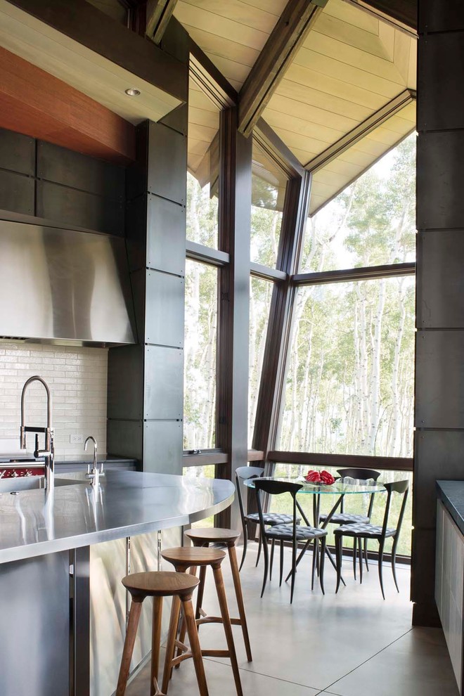Foto di una cucina contemporanea con paraspruzzi bianco, paraspruzzi con piastrelle diamantate e pavimento in cemento
