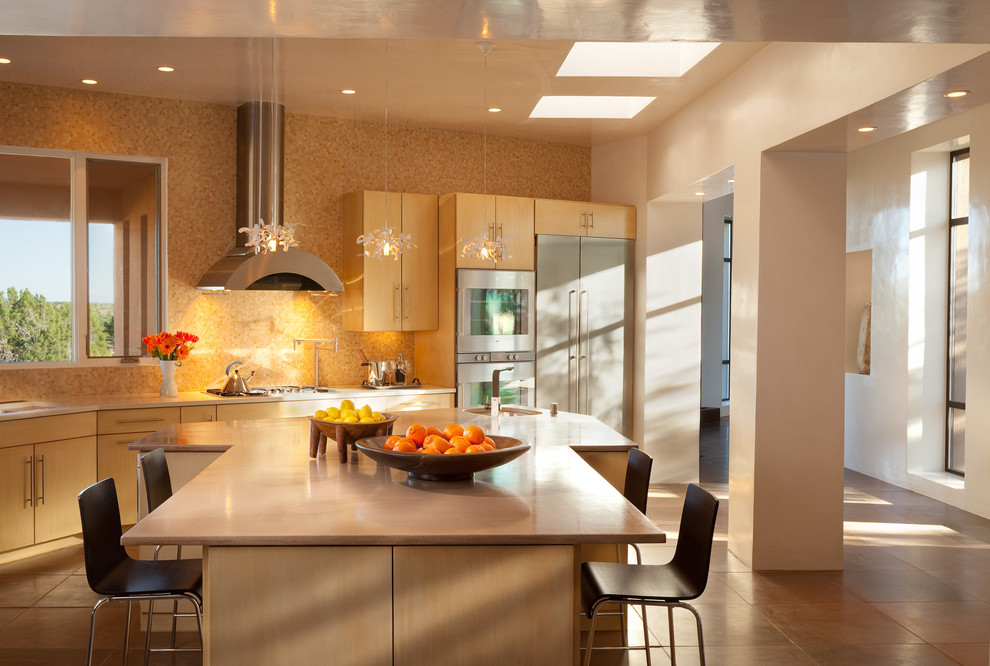 Moderne Küche mit flächenbündigen Schrankfronten, hellen Holzschränken, Küchenrückwand in Beige, Küchengeräten aus Edelstahl und Kücheninsel in Albuquerque