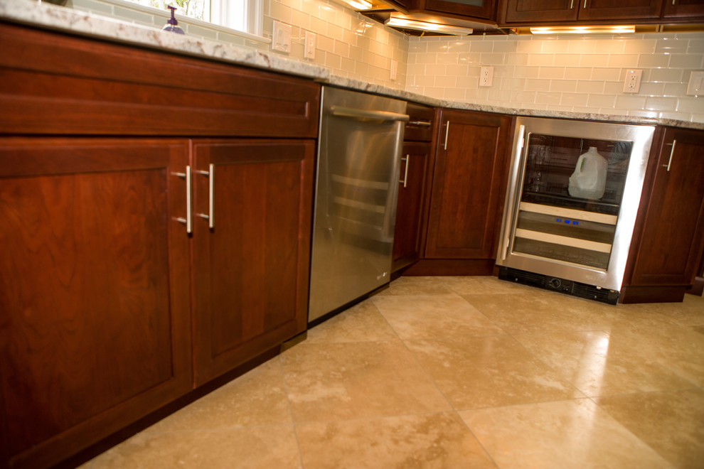 Esempio di un'ampia cucina tradizionale con lavello sottopiano, ante in legno bruno, top in granito, paraspruzzi con piastrelle di vetro, elettrodomestici in acciaio inossidabile e pavimento in marmo