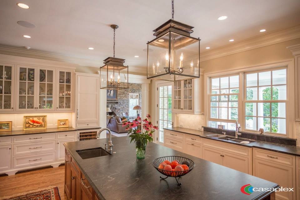 Mid-sized elegant galley light wood floor eat-in kitchen photo in DC Metro with white cabinets and an island