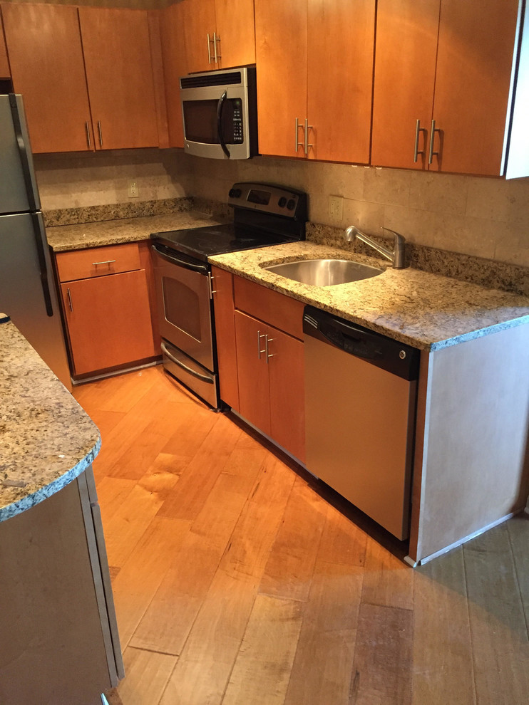 Foto på ett mellanstort funkis kök, med en undermonterad diskho, släta luckor, skåp i mellenmörkt trä, granitbänkskiva, flerfärgad stänkskydd, rostfria vitvaror och mellanmörkt trägolv