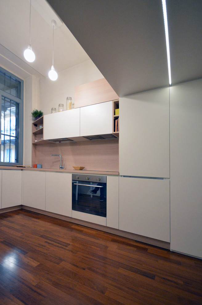 Immagine di una piccola cucina minimal con pavimento in legno verniciato e pavimento marrone