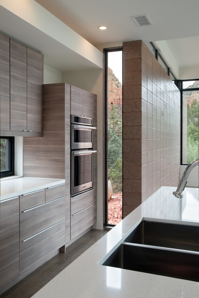 Esempio di una grande cucina moderna con lavello a doppia vasca, ante lisce, ante in legno scuro, top in quarzo composito, elettrodomestici in acciaio inossidabile e pavimento in cemento